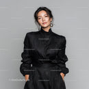 Elegant Woman in Black Dress with Statement Earrings in Studio