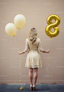 Woman celebrating with balloons and elegant lace dress