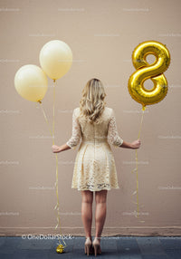 Woman celebrating with balloons and elegant lace dress