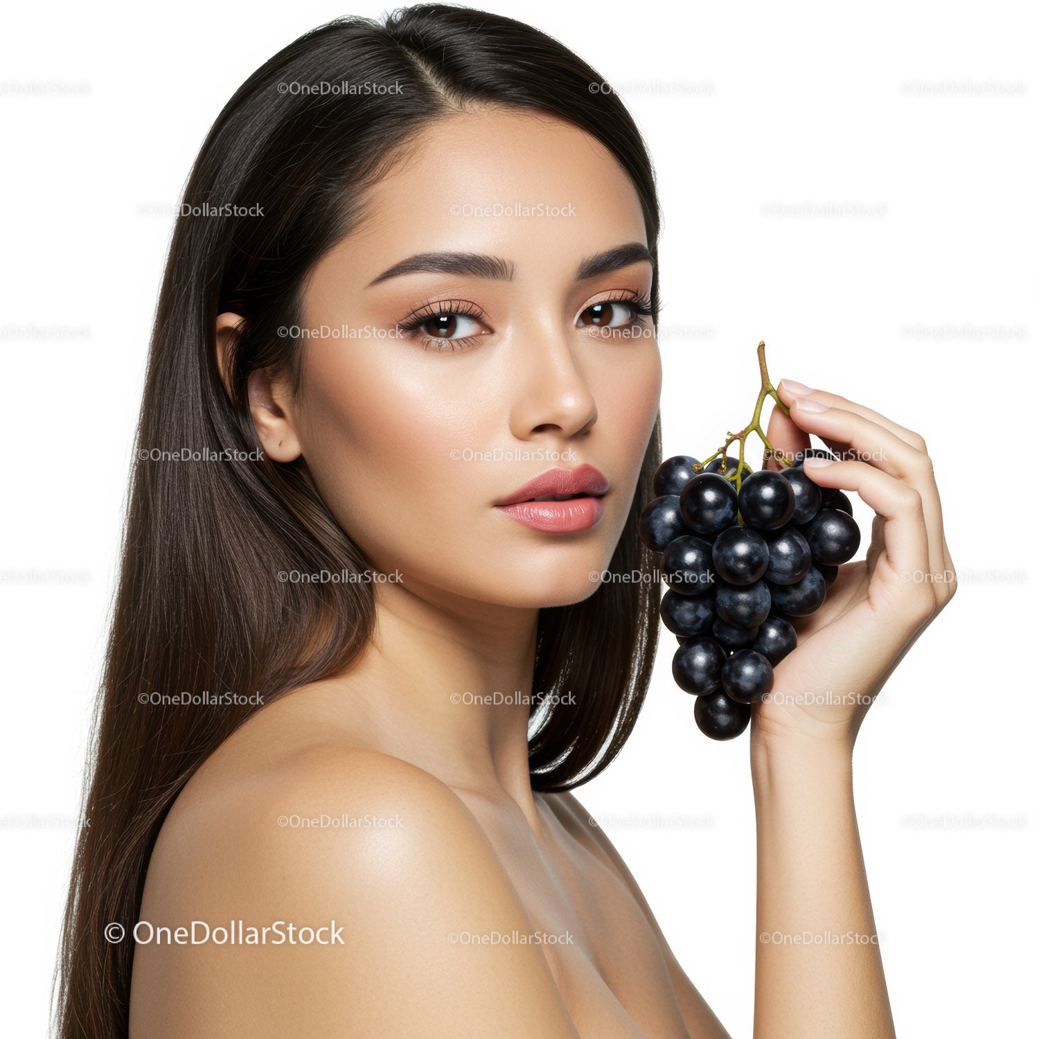 Elegant woman holding black grapes with perfect skin and natural beauty