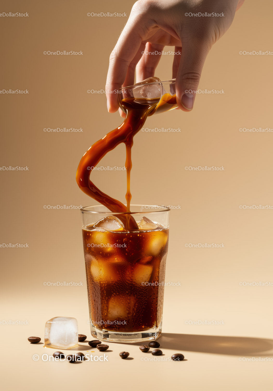 Hand Pouring Iced Coffee Over Glass with Coffee Beans