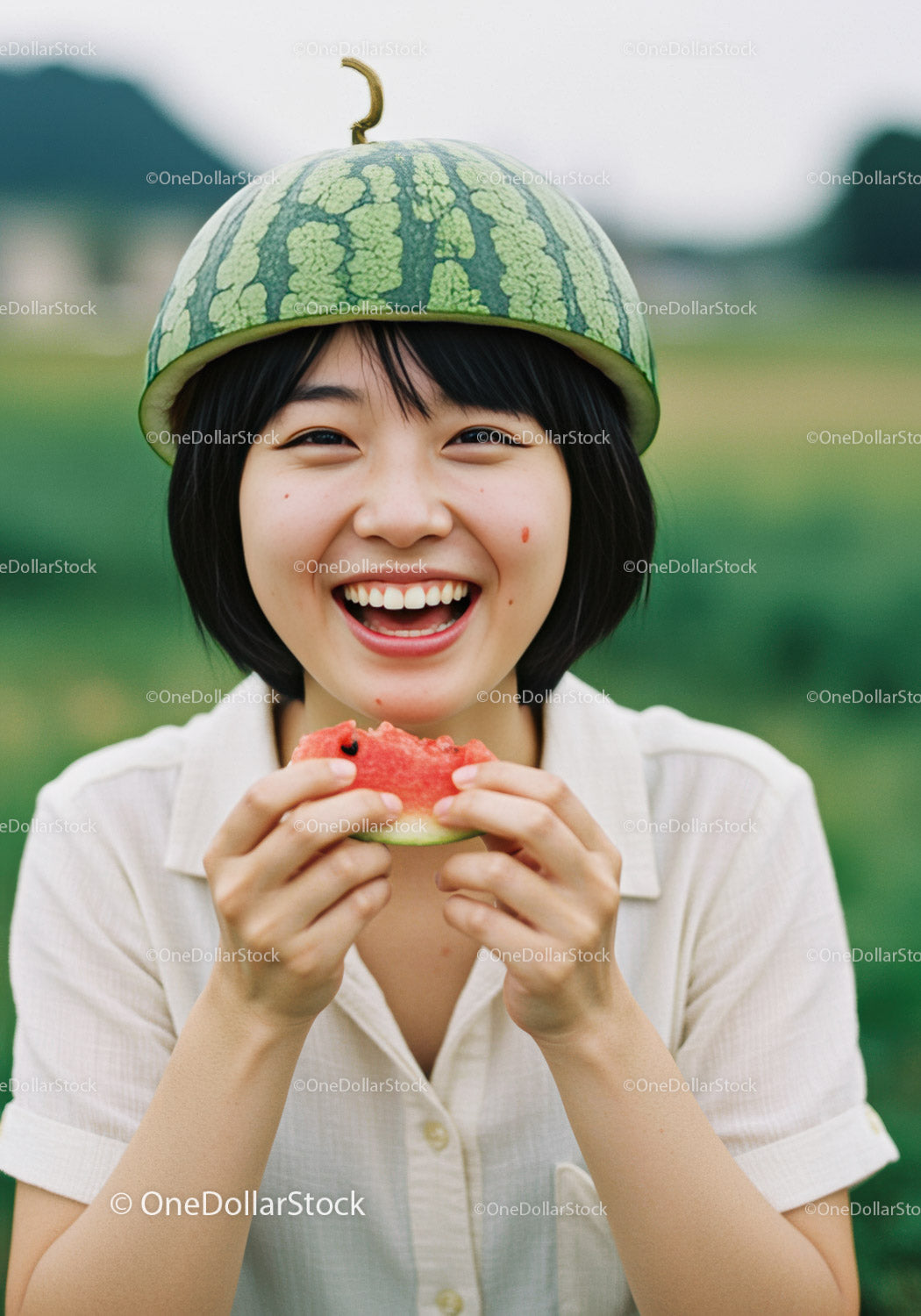 Smiling woman wearing watermelon hat eating fruit slice