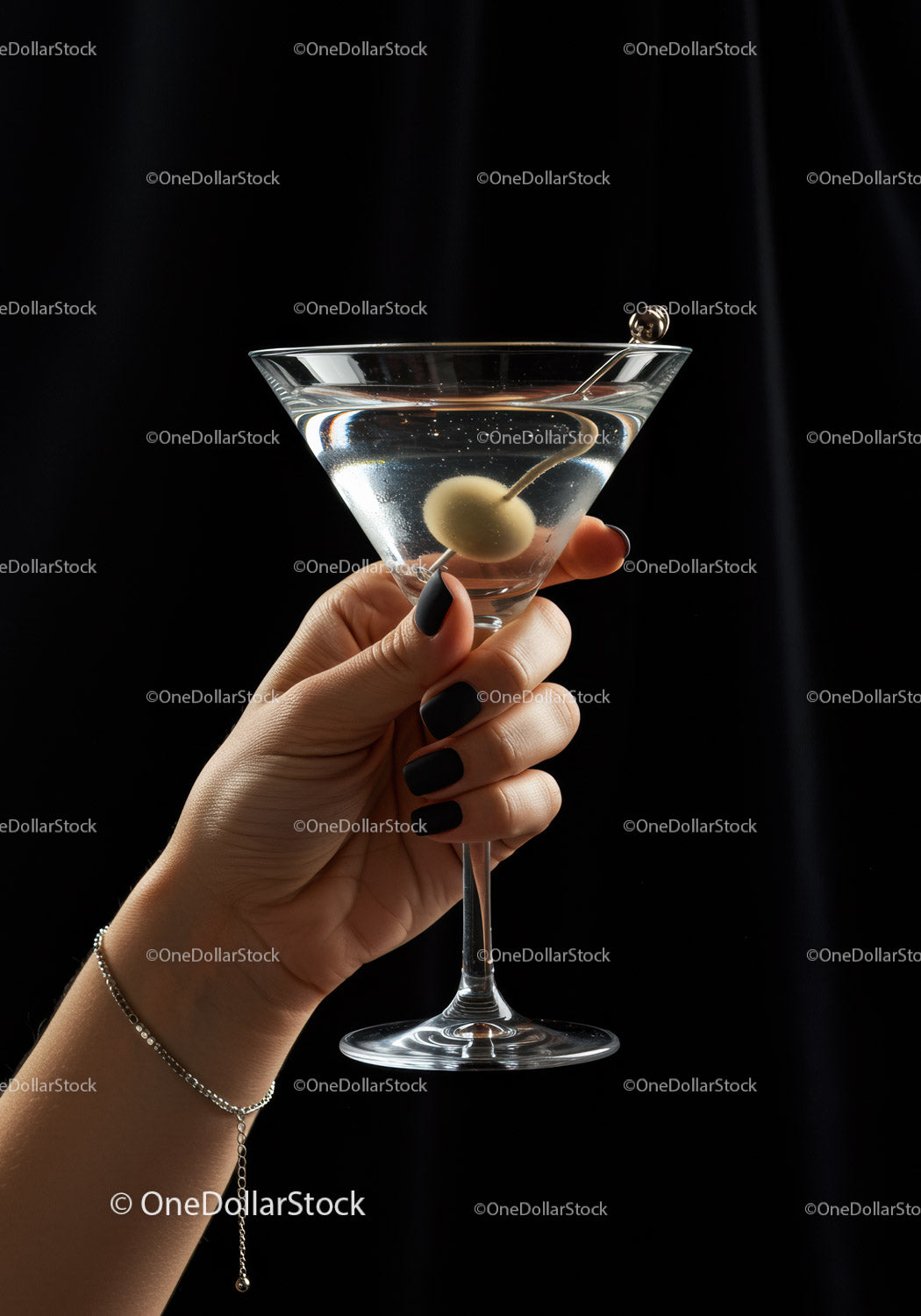 Hand Holding Classic Martini Glass with Olive Garnish