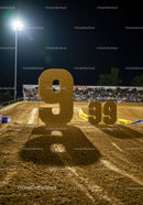 Large illuminated number nine on dirt race track at night