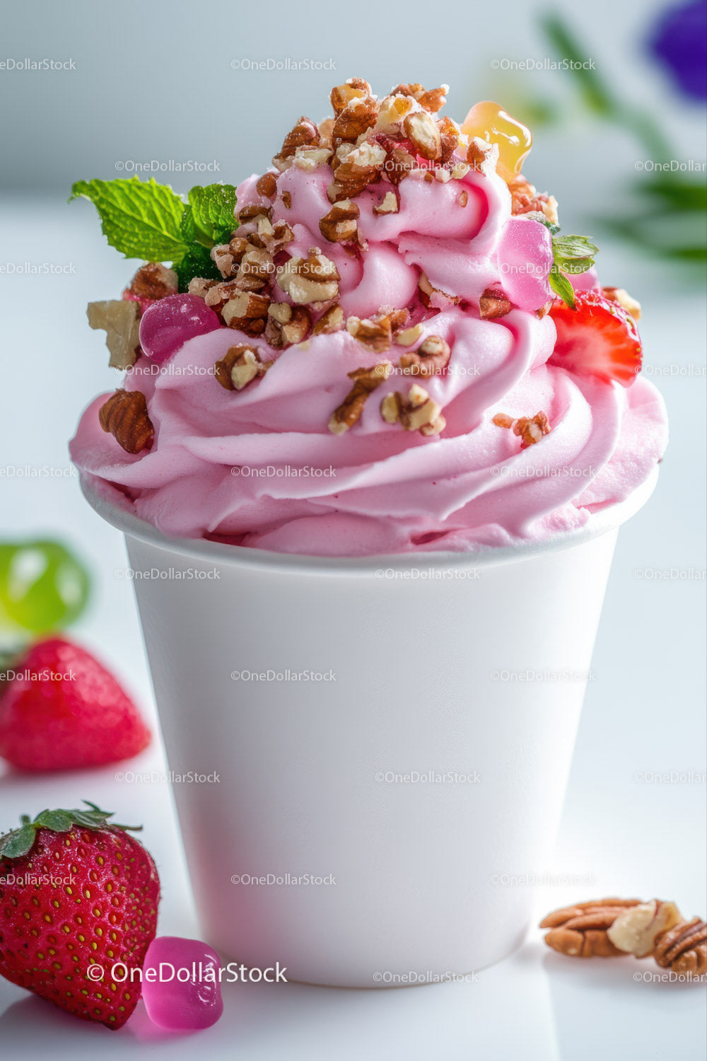 Pink Ice Cream with Strawberries Mint and Nuts in a White Cup