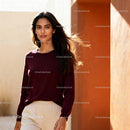 Confident woman with flowing hair standing by warm wall