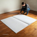Person kneeling to flip pages of oversized blank book