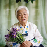 Elderly woman holding purple irises with tearful eyes