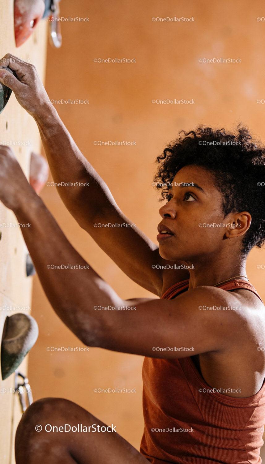 Focused woman climbing an indoor rock wall