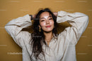 Elegant Young Woman with Long Wavy Hair Wearing Gold Jewelry