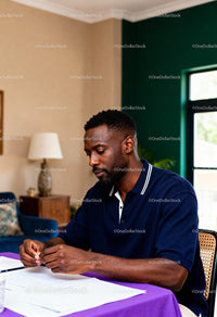 Focused man reviewing documents at home desk