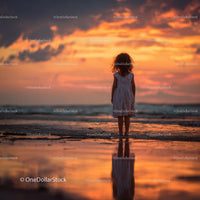 Silhouette of a Child at Sunset by the Ocean Shore
