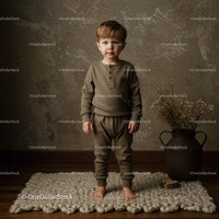 Toddler standing barefoot on soft rug in cozy outfit