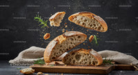 Rustic artisan bread slices flying with fresh herbs