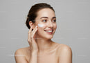 Happy Woman Applying Cream for Skincare Routine with Clear Skin