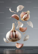 Floating garlic cloves and peeling skin on gray background