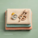 Stack of Baby Blankets with Pacifier and Wooden Rattle