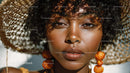 Portrait of a Beautiful Woman in Large Straw Hat with Orange Jewelry