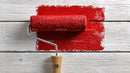 Red Paint Roller on White Wooden Surface for Interior Decor