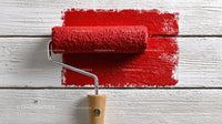 Red Paint Roller on White Wooden Surface for Interior Decor