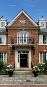 Elegant brick house entrance with blooming flower pots