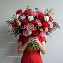 Woman in Red Holding Large Vibrant Flower Bouquet