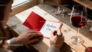 Woman writing a heartfelt love note in red card