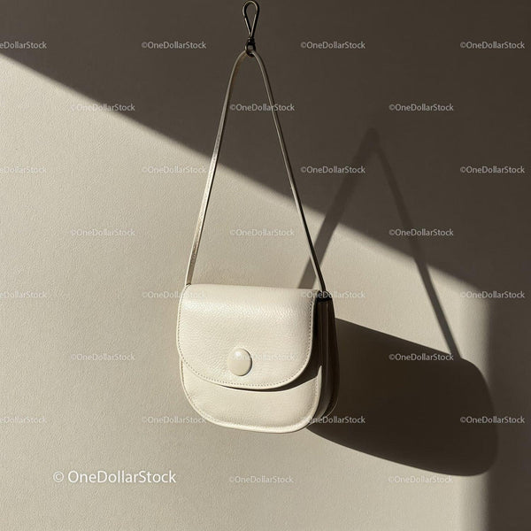 Minimalist white leather handbag hanging on wall JPG Mockup Image