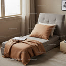 Cozy Bedroom with Beige and Gray Bed Setup with Pillows and Natural Light