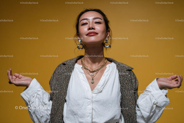 Confident Woman Wearing Jewelry with Yellow Background