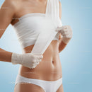 Woman Applying Medical Bandage to Her Midsection in Healthcare Setting
