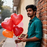 Man holding heart balloons and chocolates outdoors