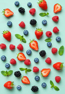 Fresh mixed berries with mint leaves on blue background