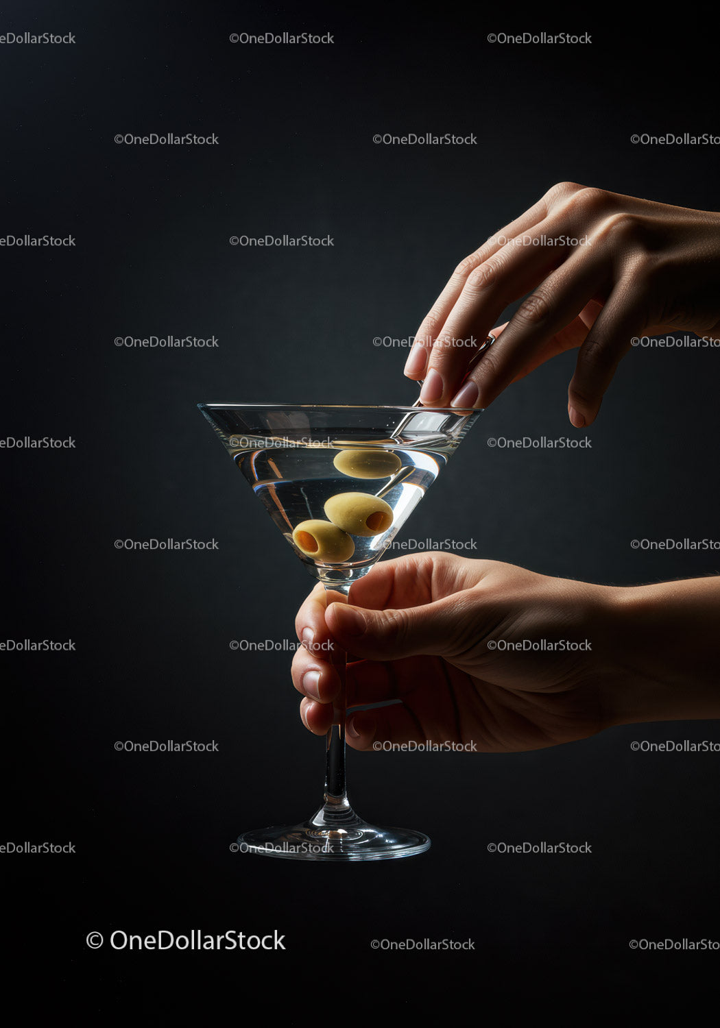 Elegant hand holding martini glass with olives