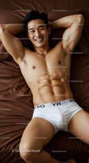 Smiling athletic man relaxing on brown bed linen