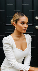 Elegant woman in white dress with pearl earrings