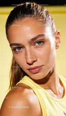Focused young athlete with glistening skin in yellow top