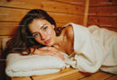 Relaxed Woman with Brown Hair Lying on Wooden Bed in Cozy Room