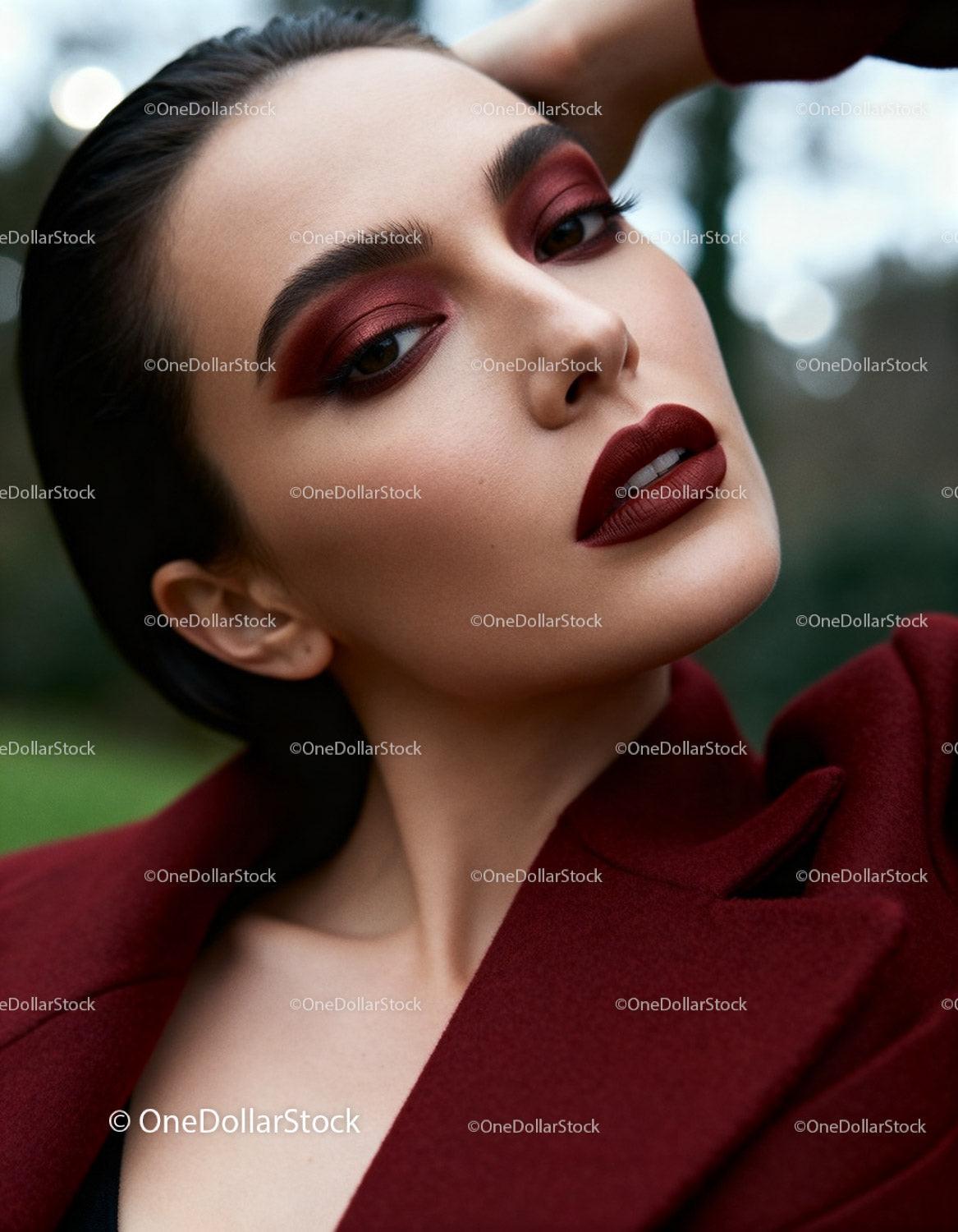 Confident woman with bold red makeup and elegant coat
