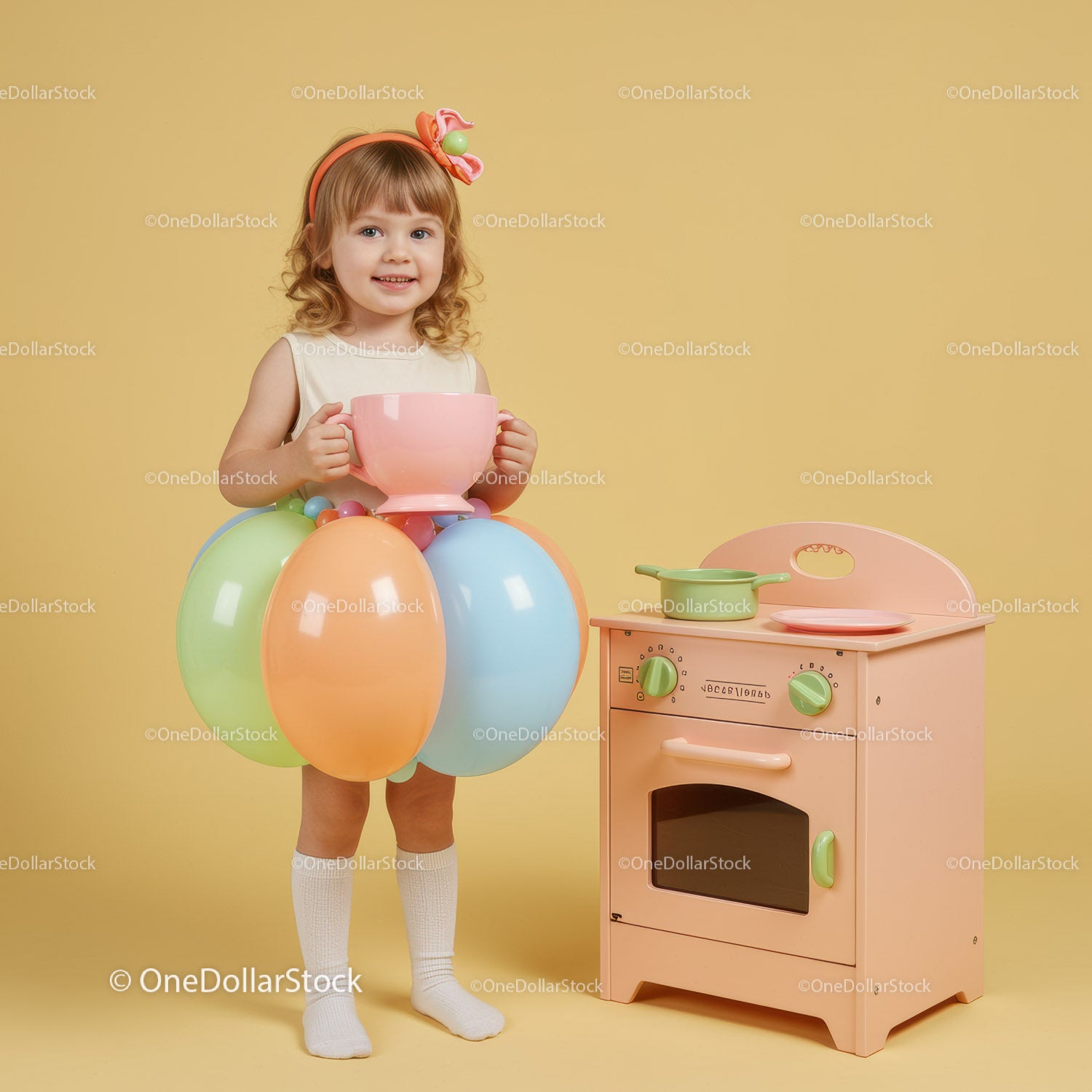 Little girl playing with colorful balloons and toy kitchen