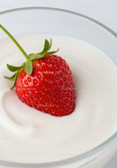 Fresh strawberry gently placed on creamy yogurt swirl