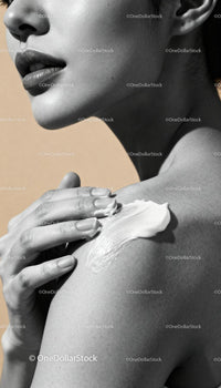 Close up of woman applying cream on shoulder