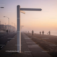 People walking and cycling on foggy beach promenade