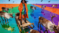 Fashion model standing on sleigh with reindeer in vivid colors