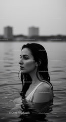 Black and White Portrait of Woman in Water with City Skyline in Background
