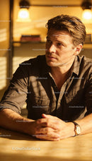 Thoughtful man in warm light sitting at wooden table