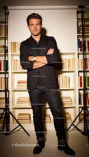 Confident man posing in stylish outfit with bookshelves