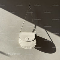 Minimalist white leather purse hanging on wall