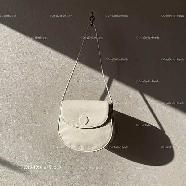 Minimalist white leather purse hanging on wall JPG Mockup Image