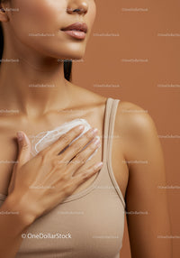 Close-up of Woman Applying Moisturizer on Cleavage with Nude Background